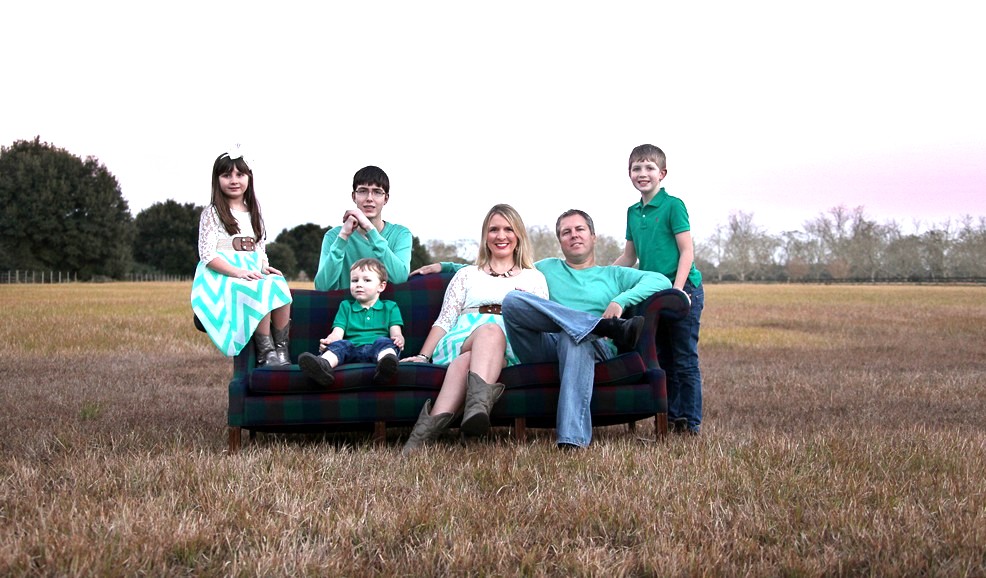 The Johnson family on a couch in a field at sunset