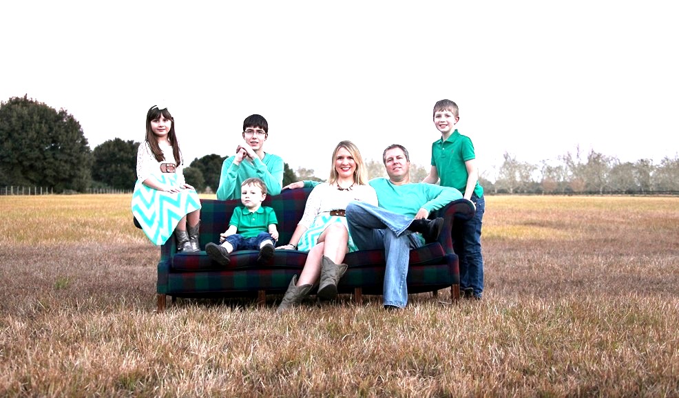 The Johnson family on a couch in a field at sunset